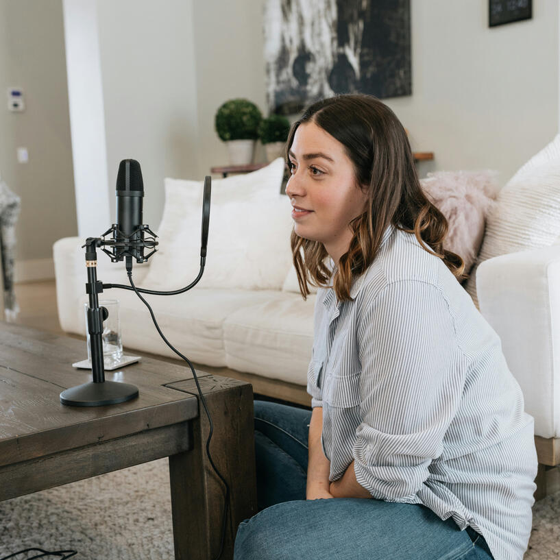life-story-studio-woman-being-recorded.jpg A woman sat casually, taking part in an audio interview, in a comfortable living room setting.